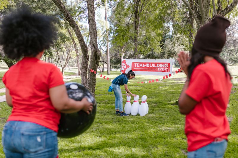 Kolege zajedno igraju kuglanje na team buildingu